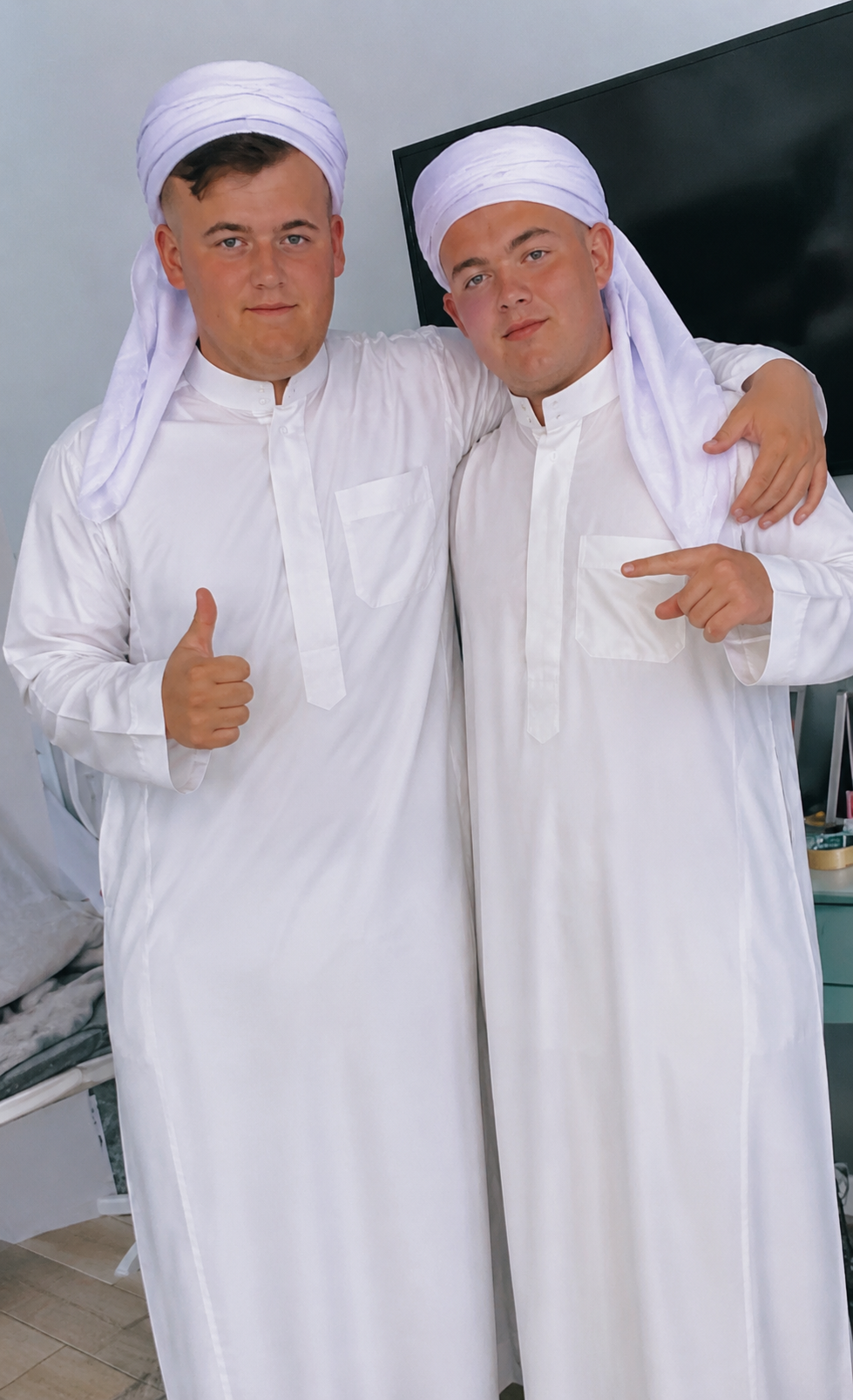 Two community members wearing white traditional clothing